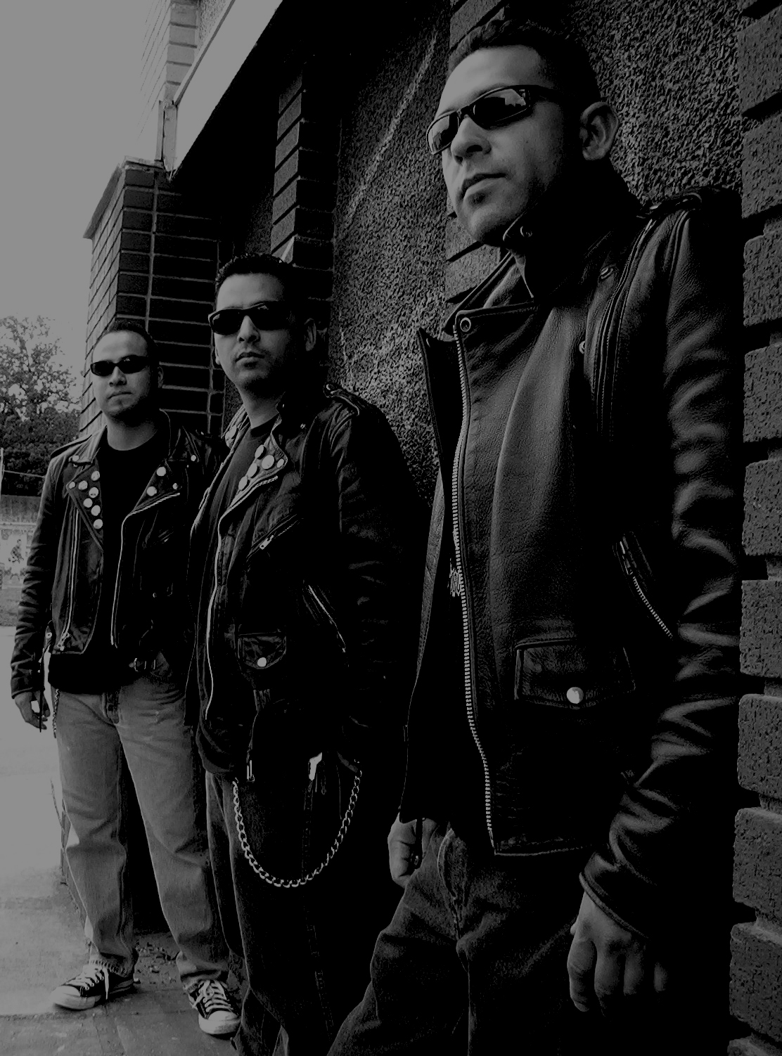 Dementers band promo photo in black and white: three members in leather jackets against a brick wall